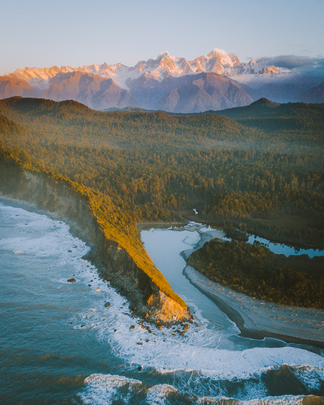A Drone Shot Of The Wild Coastline With The Southern Alps In The Background
