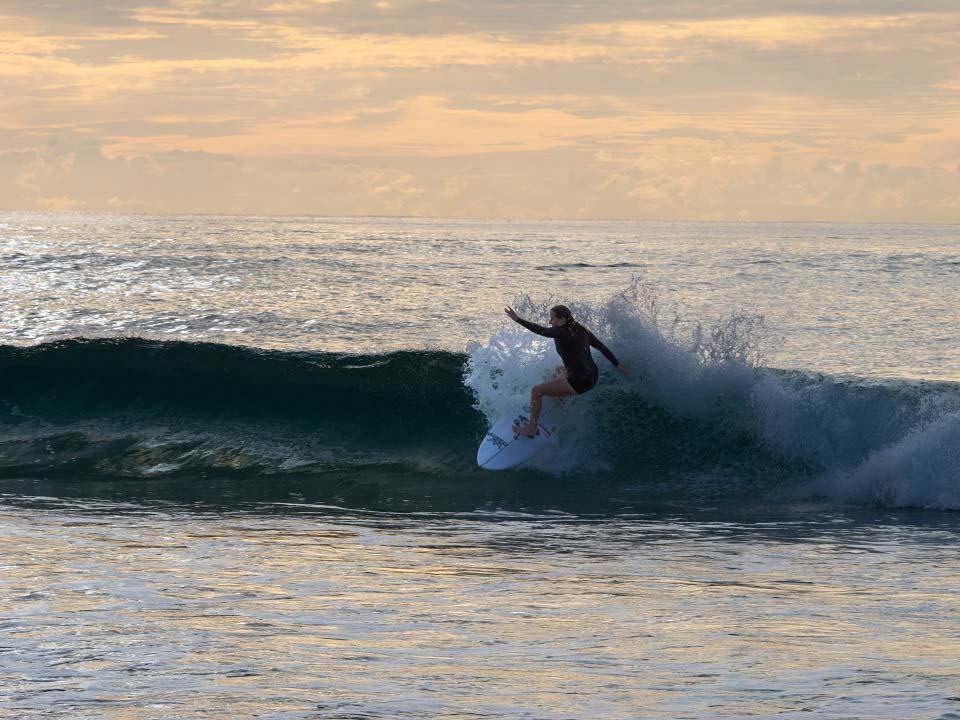 Surfer India Robinson catching some waves