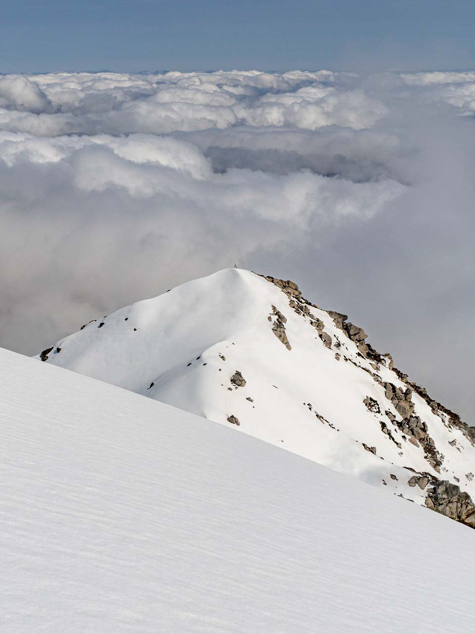 At the peak of a snow mountain in the midst of clouds