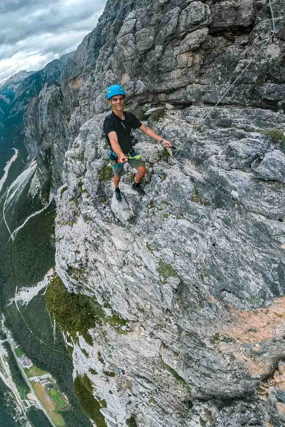 Wide fisheye shot of Zach Bostock on steel ladders to the summit